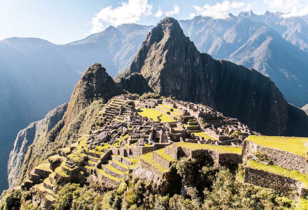 una vista de la montaña y los árboles verdes en Machu Picchu