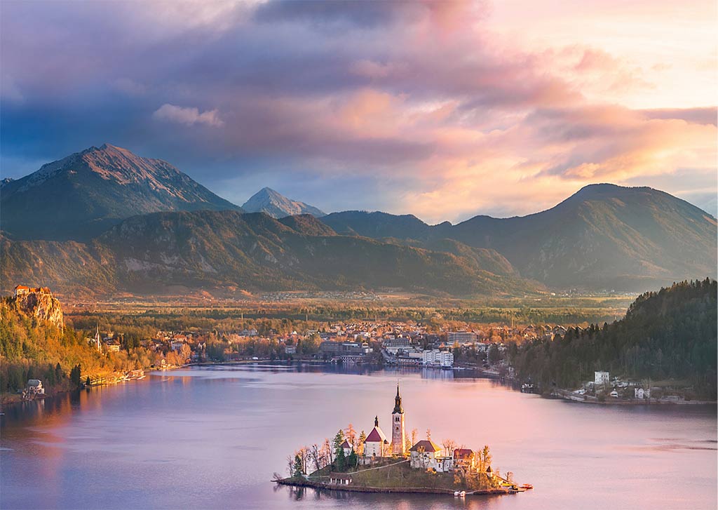 una vista sobre el cielo del alfiler, las montañas y el lago Bled que es uno de los hermosos lugares de la lista de cubos