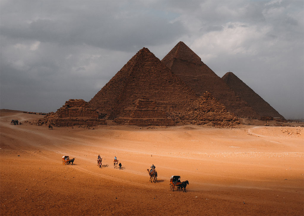foto marrón con pirámides de Guiza en Egipto y camellos, uno de los lugares de la lista de cubos de ensueño que necesita visitar