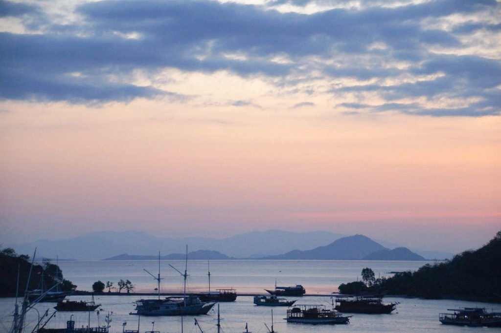 vista en un puerto de Labuan Bajo durante la puesta del sol con varios barcos alrededor