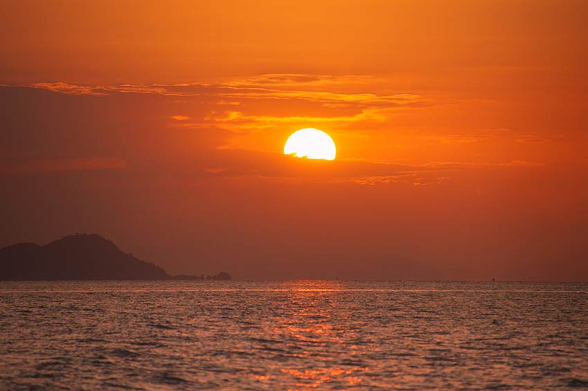 cielo naranja con el sol que se pone sobre el mar