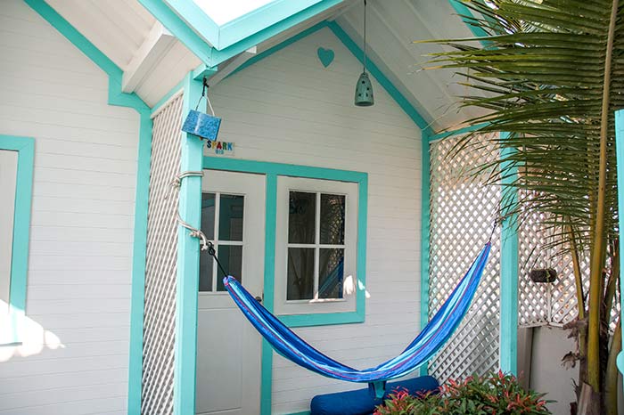 casa blanca con marco azul y hamaca azul