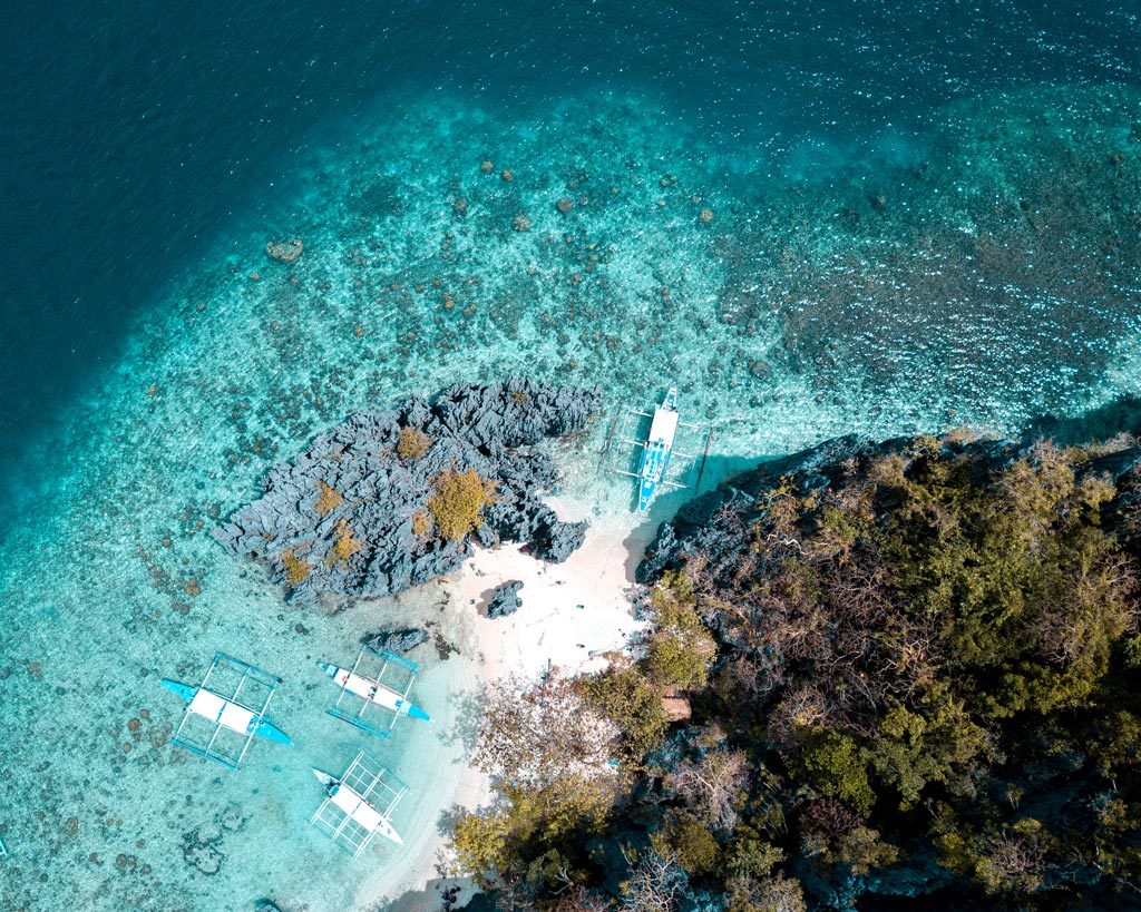 vista de drones en wate azul, barcos e isla en Filipinas