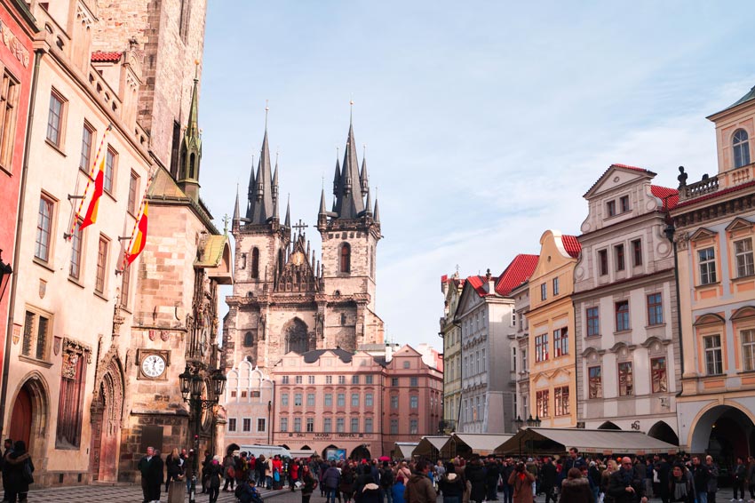 una vista en la torre de dos torres con edificios coloridos y muchas personas alrededor en la plaza del casco antiguo de Praga