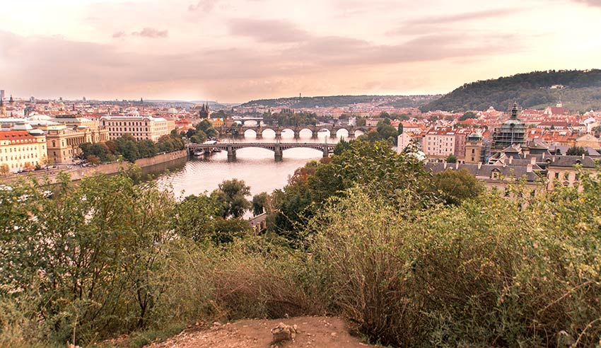 una vista en los puentes de Praga, arbusto verde y cielo meñique en el parque Letna que es un lugar de fotos obligadas en Praga